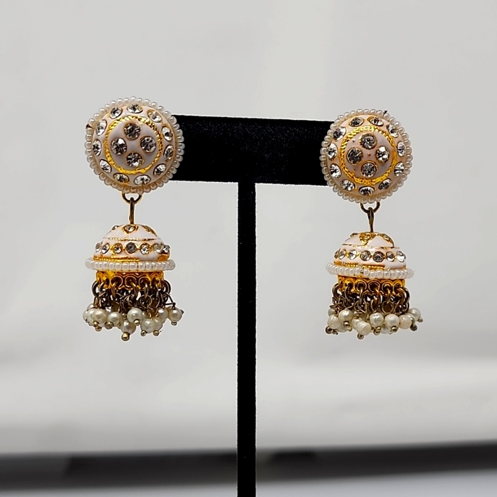 Vintage rhinestone & faux pearl earrings on white and gold color.